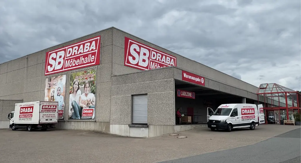 SB DRABA Möbelhalle mit Werbeschildern, Lieferfahrzeugen, Warenausgabe und Ladezone